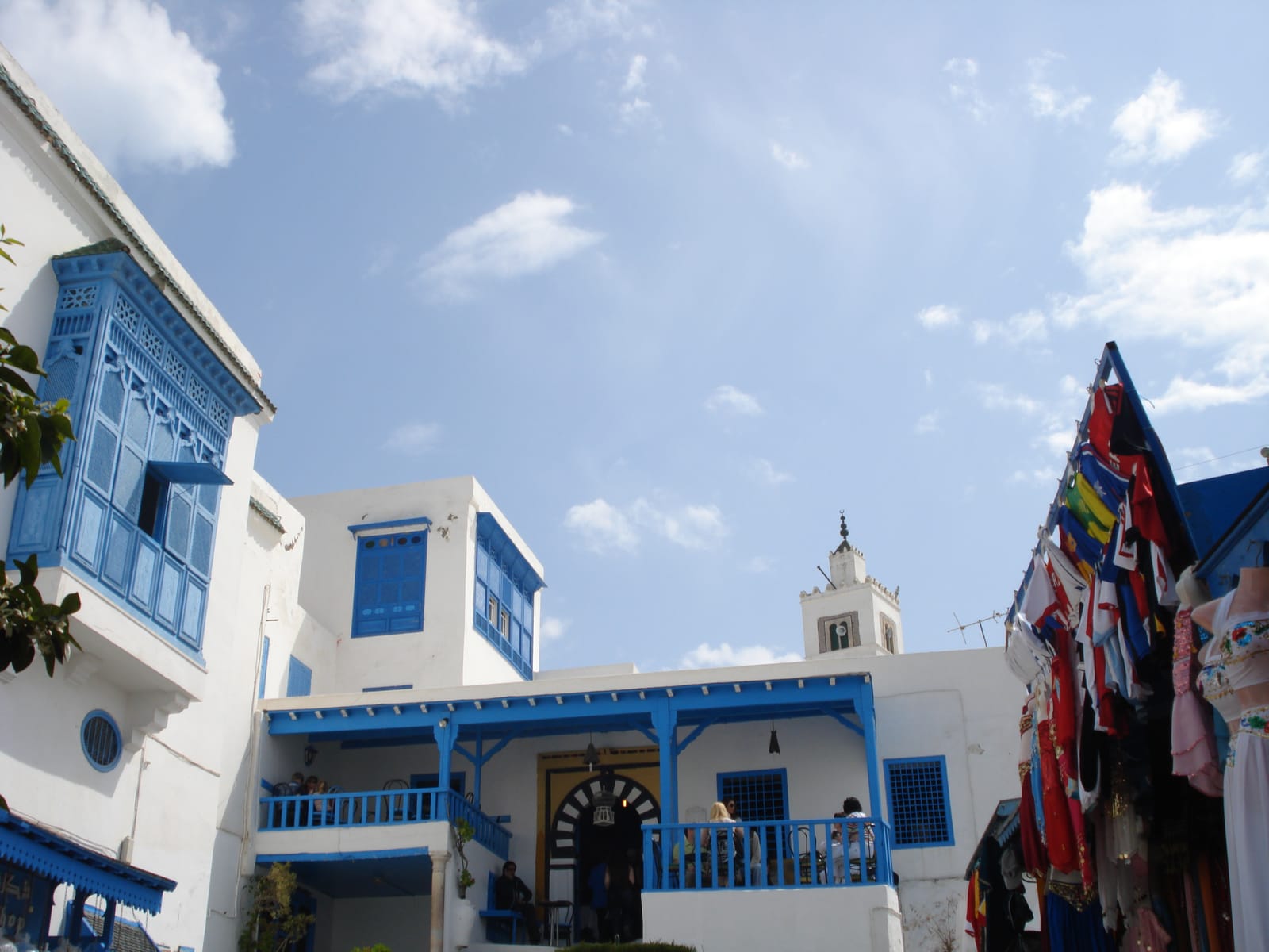 The blue-and-white façade of the Café des Nattes beside the mosque minaret