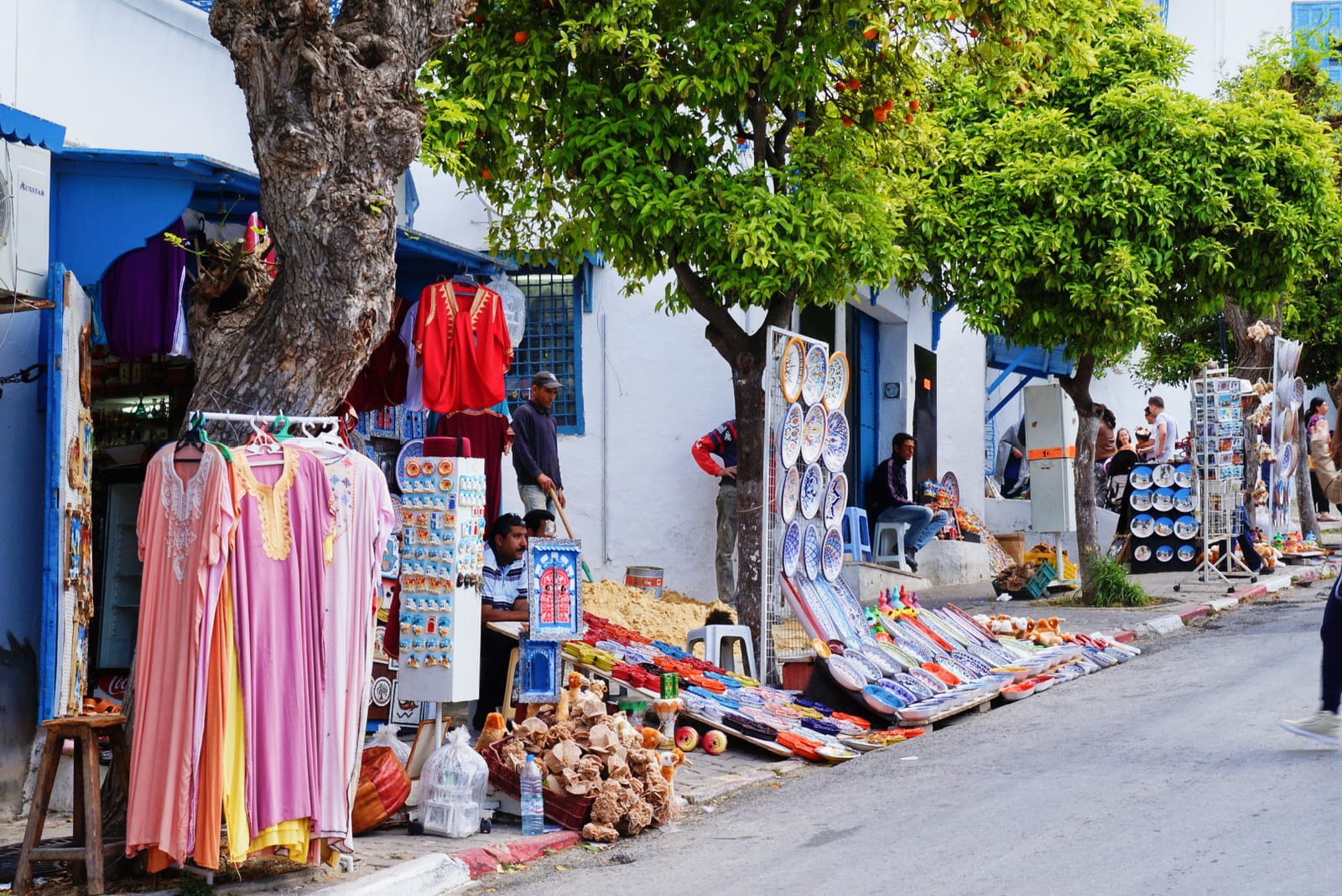 Souvenir and ceramic stalls lining a blue-and-white street in Sidi Bou Said